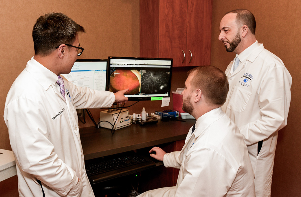 Retina specialist reviewing retinal imaging before uveitis treatment.