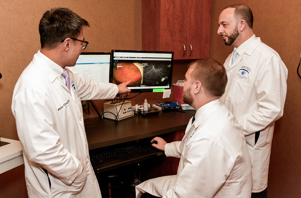 Retina specialist reviewing retinal imaging for a patient with flashes and floaters