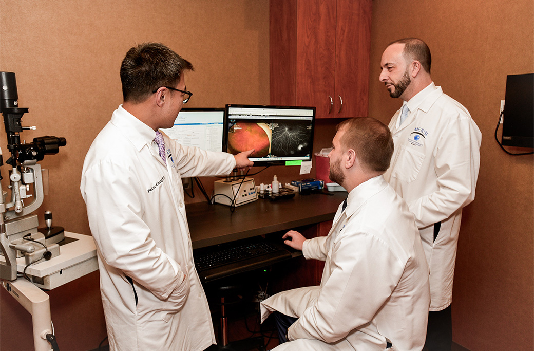 Retina specialist reviewing retinal imaging with a patient experiencing floaters