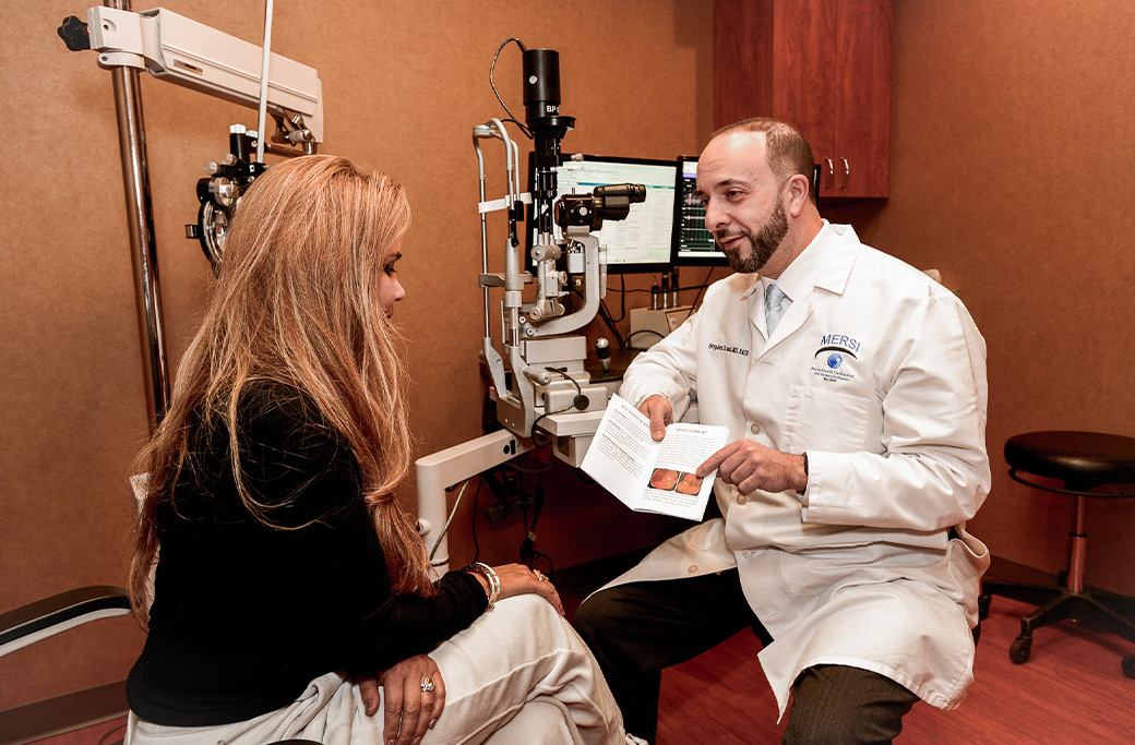 Retina specialist reviewing diagnostic imaging during a comprehensive eye evaluation