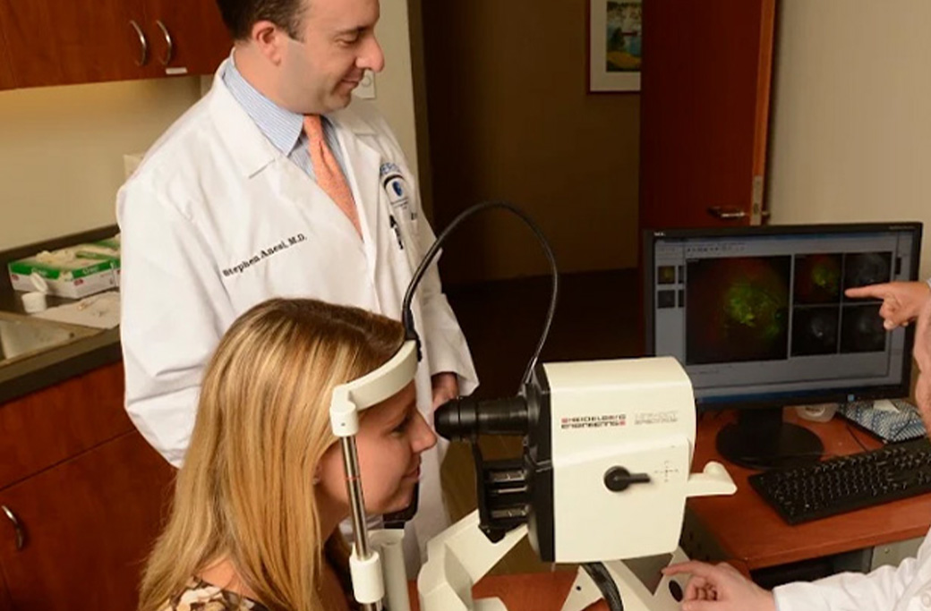 Retina specialist reviewing retinal imaging with a patient during an eye examination