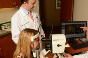 Retina specialist reviewing retinal imaging with a patient during an eye examination